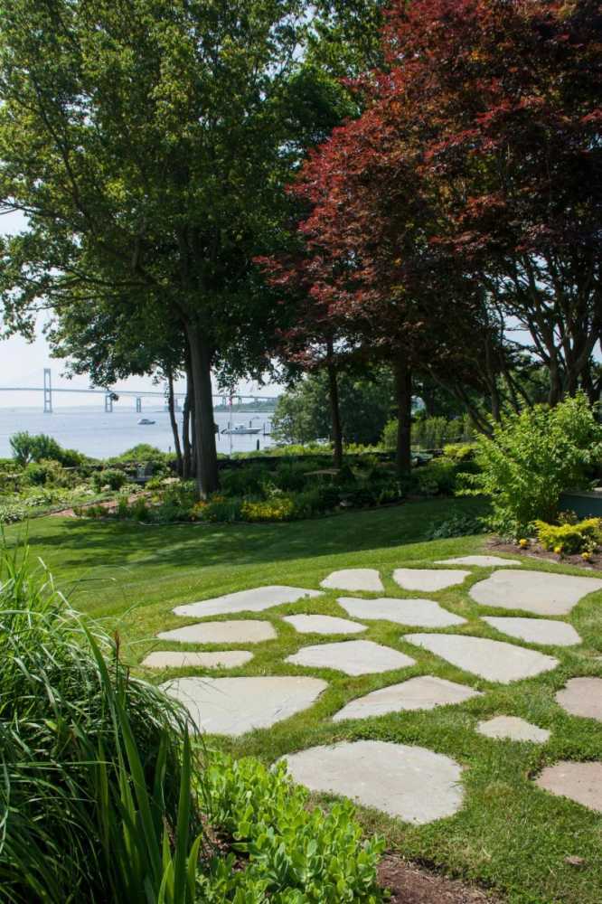 Natural shaped stone set in lawn creates a simple patio and entertaining area.  A lawn mower easily passes over these stones for simple maintenance.